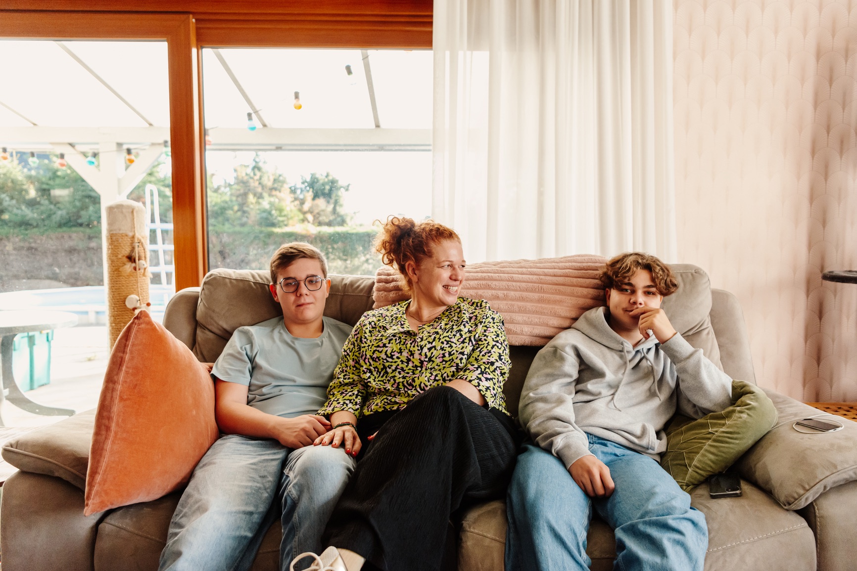 A mom on the couch with her two teenage sons